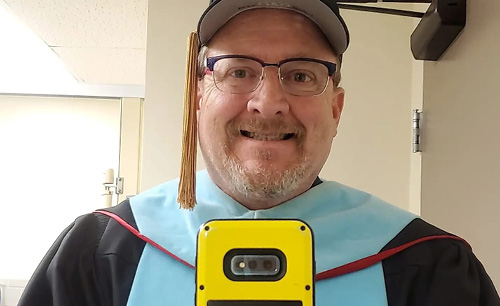 Keith taking a selfie in regalia before the school year starts