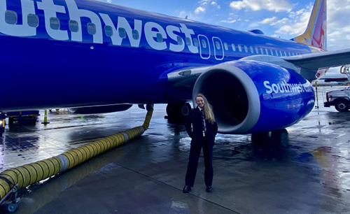 Jade Foster standing on the tarmac in front of a southwest plane