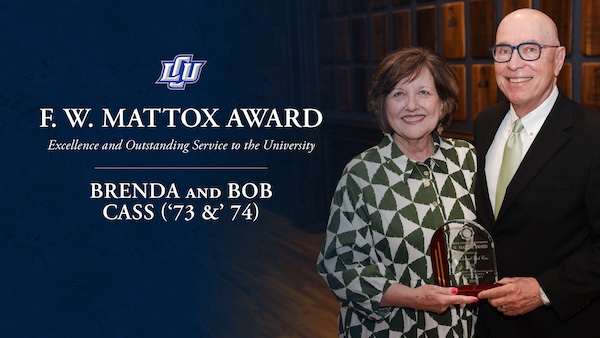 Bob and Brenda Cass holding their award with the award logo to their left