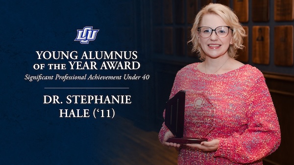 Stephanie Hale posing with her award with award logo to the right