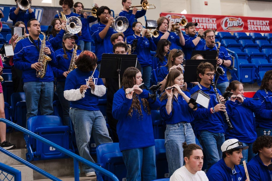 Band playing their instruments at a sporting event.