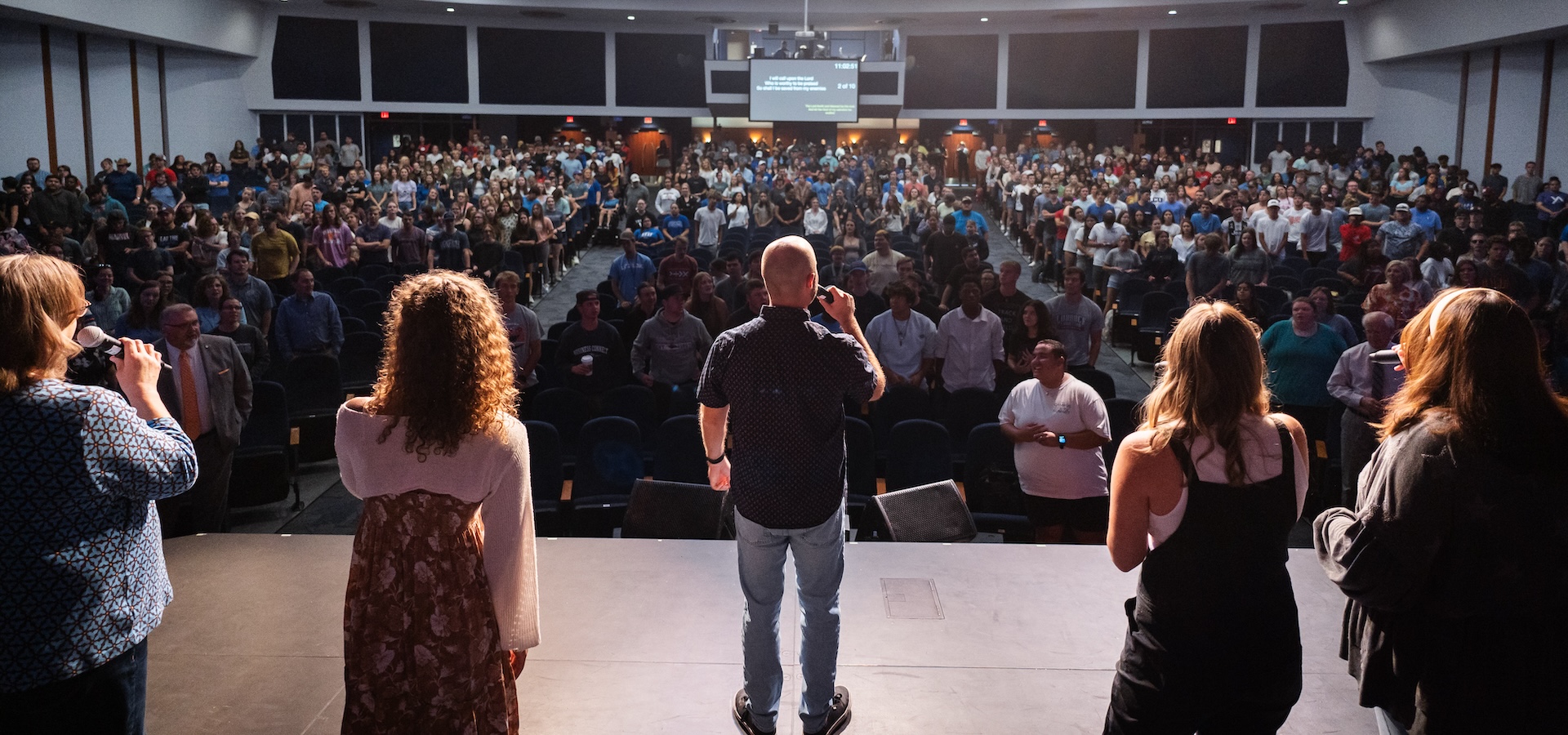 A worship team on stage leading audience in song