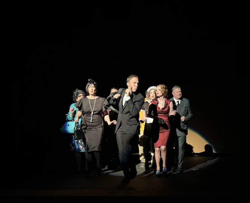 Photograph of the cast of "CLUE" in the spotlight on stage