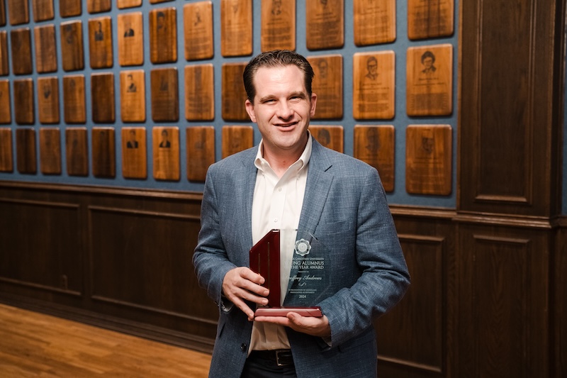 Geoffrey Andrews posing with his award