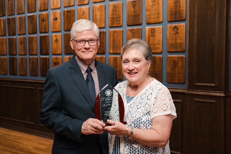 Jim and Lisa Brewer posing with their award