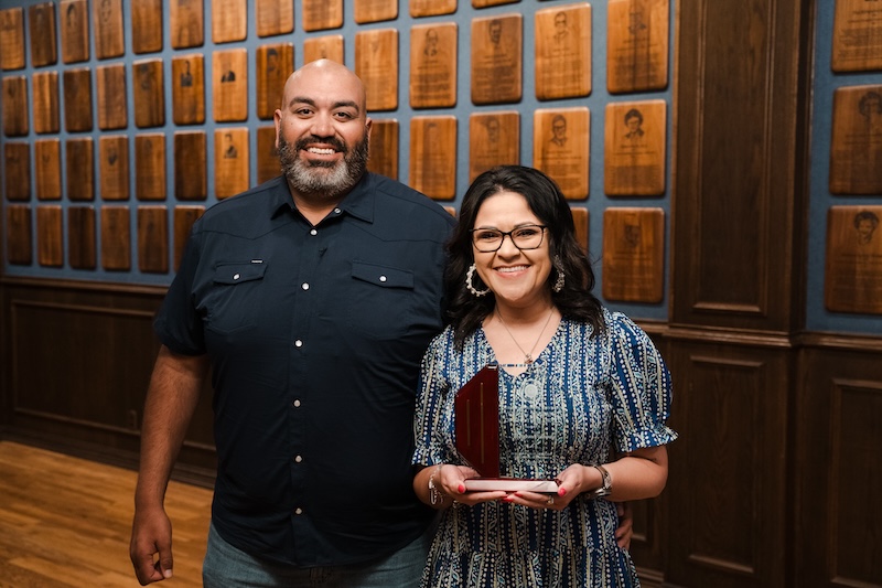 Megan Estrada and husband posing with her award