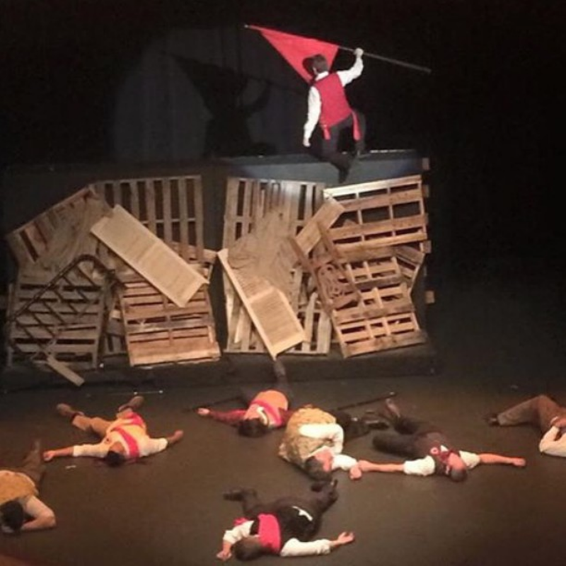 Photograph of the Barricade scene from the company's first show, Les Miserables
